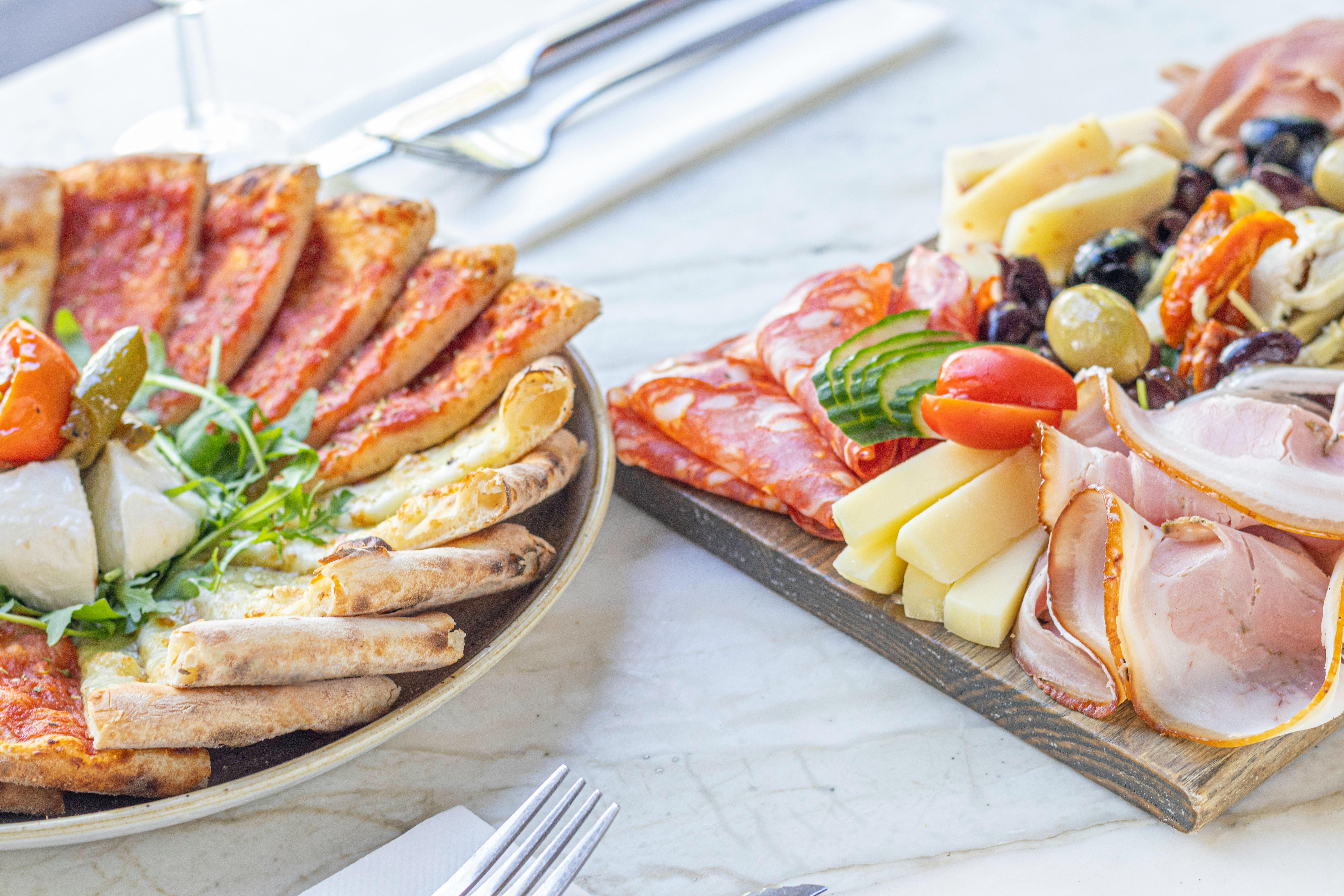Mesa de catering com pizza e acompanhamentos