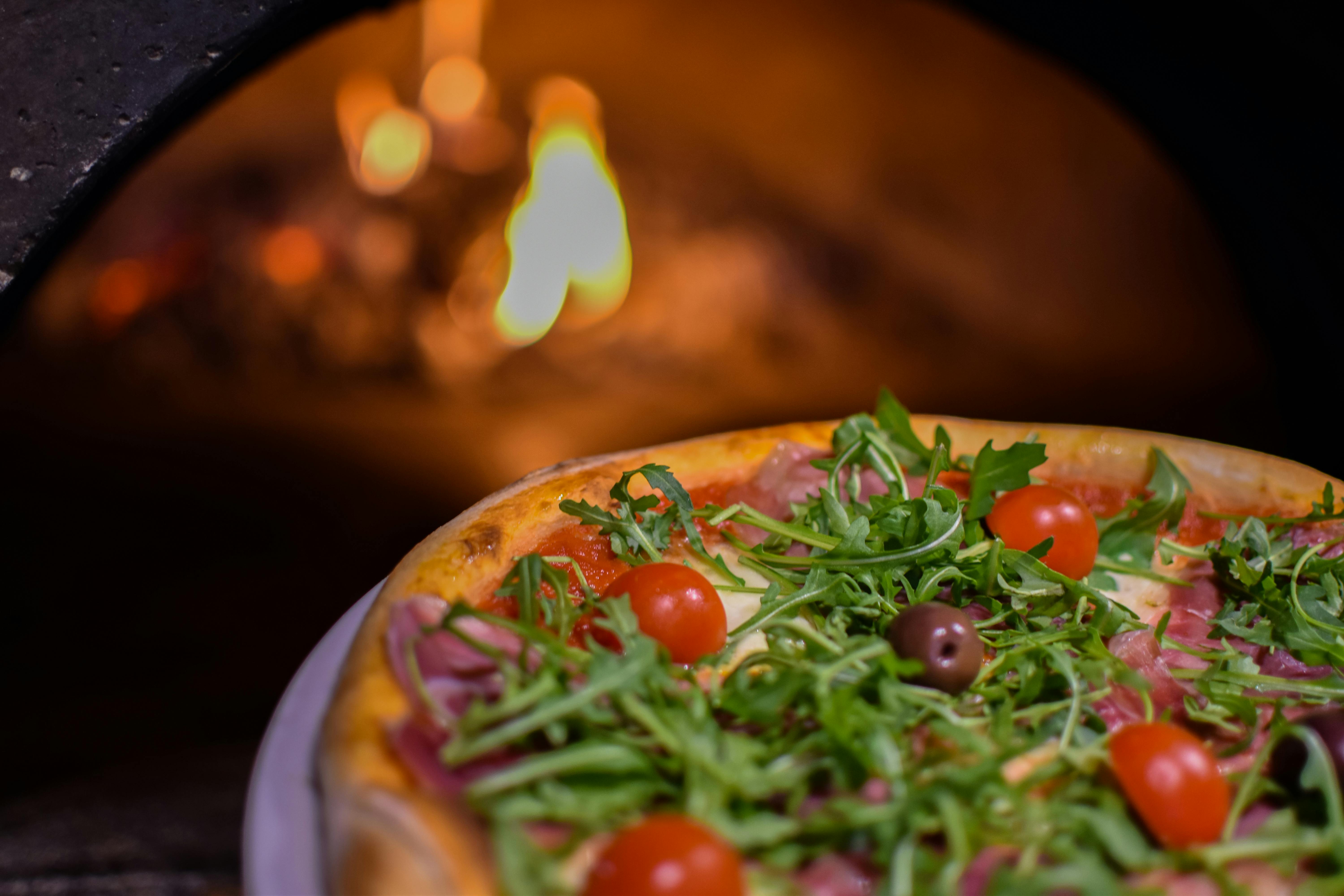 Pizza pronta com fogo ao fundo